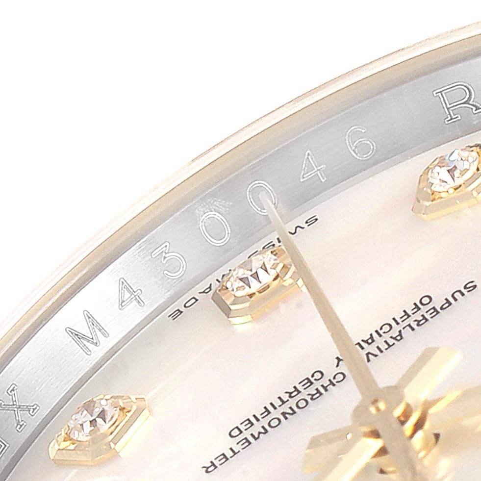 This close-up of a Rolex Datejust 116233 Men's Stainless Steel Mother of Pearl Dial 116233 Men's Stainless Steel Mother of Pearl Dial shows the dial with diamond markers and part of the bezel's serial engraving.