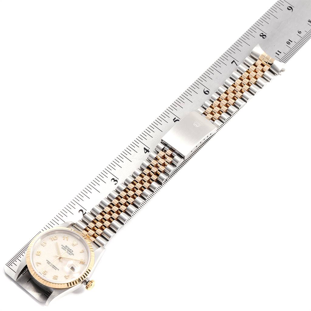 The Rolex Datejust 16233 Men
s Steel and Gold (two tone) Beige Dial 16233 Men
s Steel and Gold (two tone) Beige Dial watch is shown from an overhead angle, displaying the face, bezel, and full bracelet next to a ruler for scale.