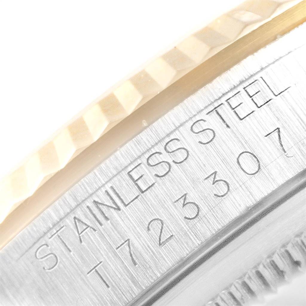 The image shows a close-up of the edge of a Rolex Datejust 16233 Men
s Steel and Gold (two tone) Beige Dial 16233 Men
s Steel and Gold (two tone) Beige Dial watch, highlighting the stainless steel material and partial serial number.
