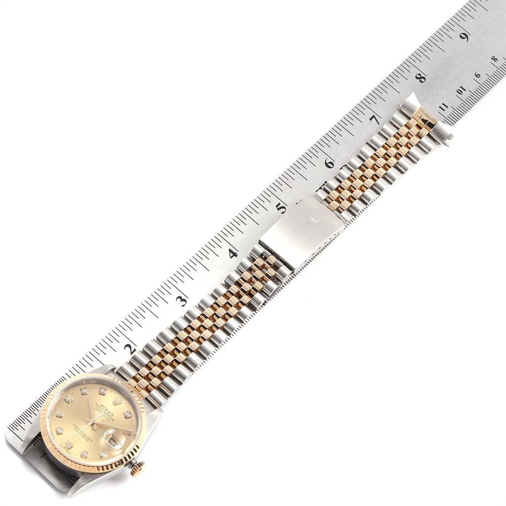 The image shows a Rolex Datejust 16233 Men's Steel and Gold (two tone) Champagne Dial 16233 Men's Steel and Gold (two tone) Champagne Dial watch laid flat with a gold and silver Jubilee bracelet beside a ruler.