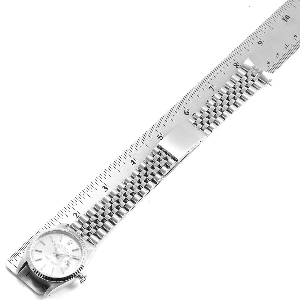 This image shows the Rolex Datejust 16234 Men's Stainless Steel Silver Dial 16234 Men's Stainless Steel Silver Dial watch laid flat with its band alongside a ruler for size reference.