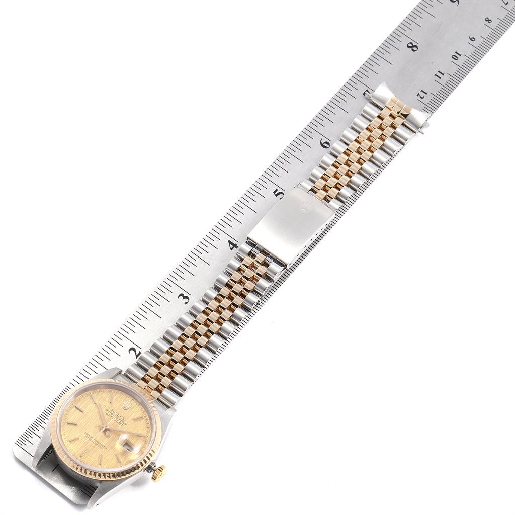 The image shows a Rolex Datejust 16233 Men's Steel and Gold (two tone) Champagne Dial 16233 Men's Steel and Gold (two tone) Champagne Dial watch from an overhead angle, highlighting the face, bezel, and bracelet against a ruler.