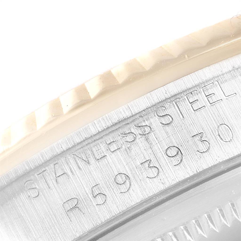 The image shows a close-up of the side of a Rolex Datejust 16233 Men's Steel and Gold (two tone) Champagne Dial 16233 Men's Steel and Gold (two tone) Champagne Dial watch, highlighting the stainless steel engravings and part of the fluted bezel.