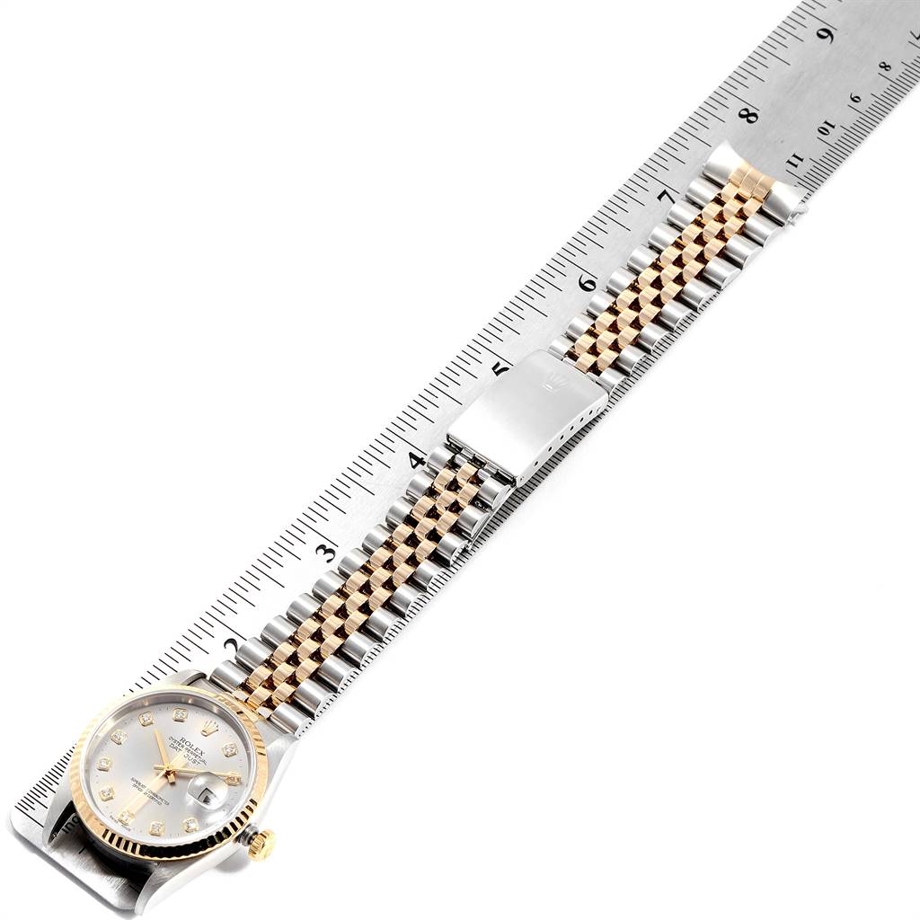 This image shows the Rolex Datejust 16233 Men's Steel and Gold (two tone) Grey Dial 16233 Men's Steel and Gold (two tone) Grey Dial watch laid flat next to a ruler, highlighting its face and two-tone bracelet.