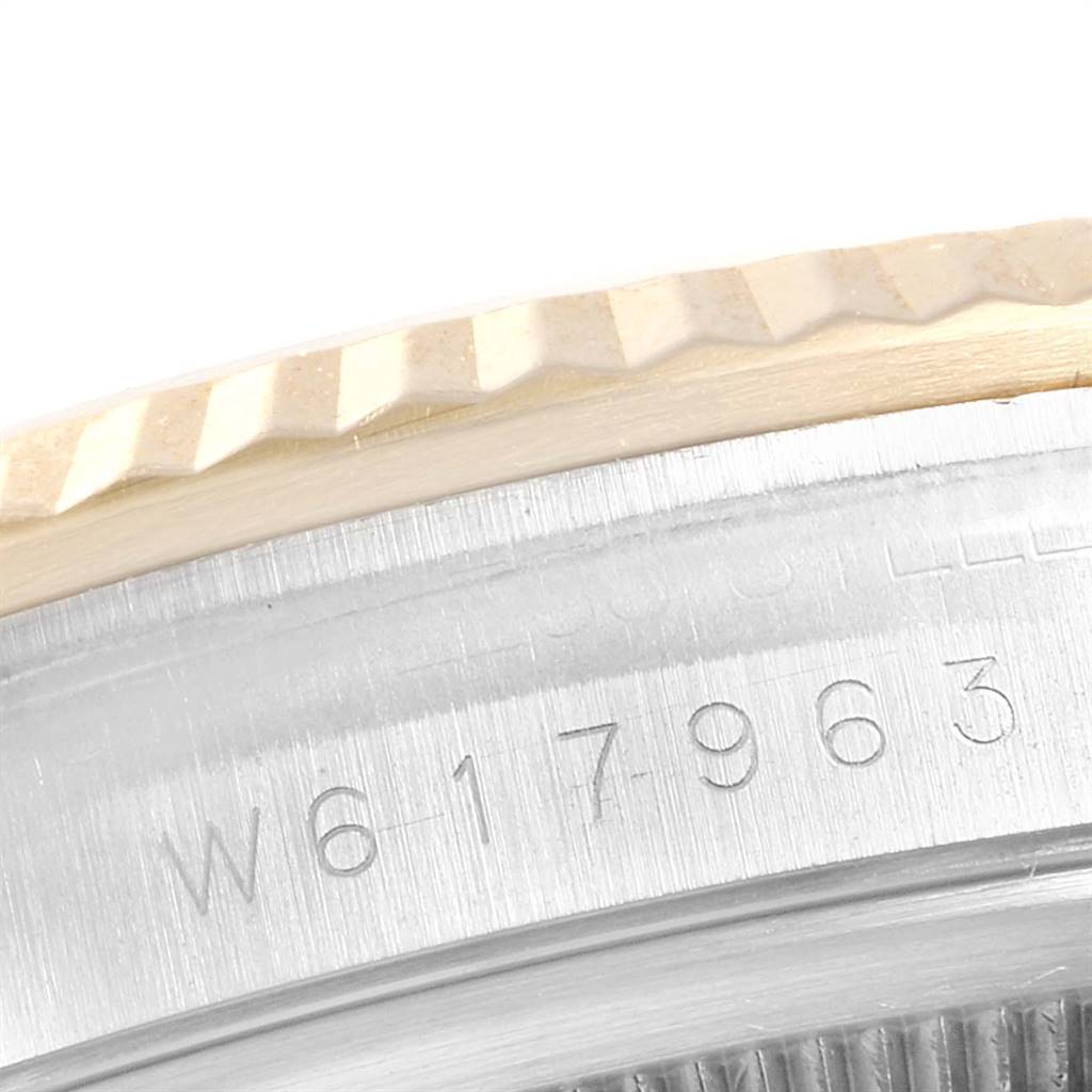 The image shows a close-up of the Rolex Datejust 16233 Men's Steel and Gold (two tone) Grey Dial 16233 Men's Steel and Gold (two tone) Grey Dial watch's serial number and part of its fluted bezel.