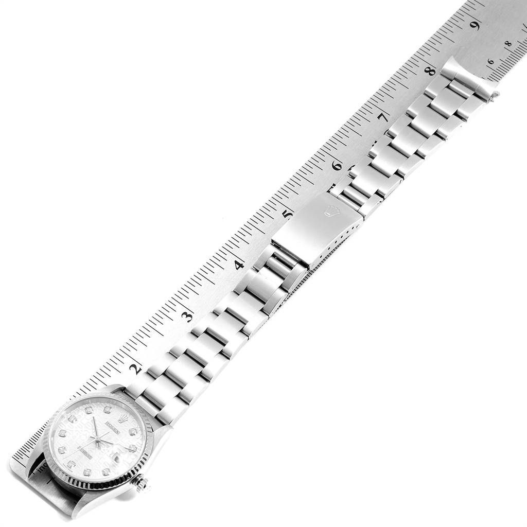 This image shows a top view of the Rolex Datejust 16234 Men's Stainless Steel Silver Dial 16234 Men's Stainless Steel Silver Dial watch placed beside a ruler, highlighting its bracelet and clasp.