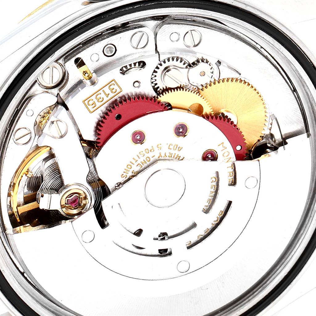 The image shows an internal view of the Rolex Datejust 16233 Men
s Steel and Gold (two tone) Black Dial 16233 Men
s Steel and Gold (two tone) Black Dial model
s movement mechanisms, featuring gears and screws.