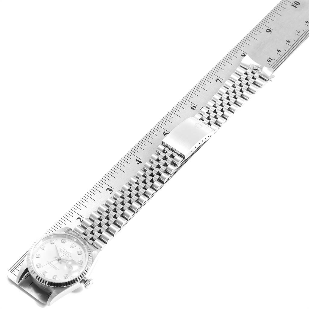 The image shows a Rolex Datejust 16234 Men's Stainless Steel Silver Dial 16234 Men's Stainless Steel Silver Dial watch laid flat next to a ruler, emphasizing its dial, bracelet, and clasp.