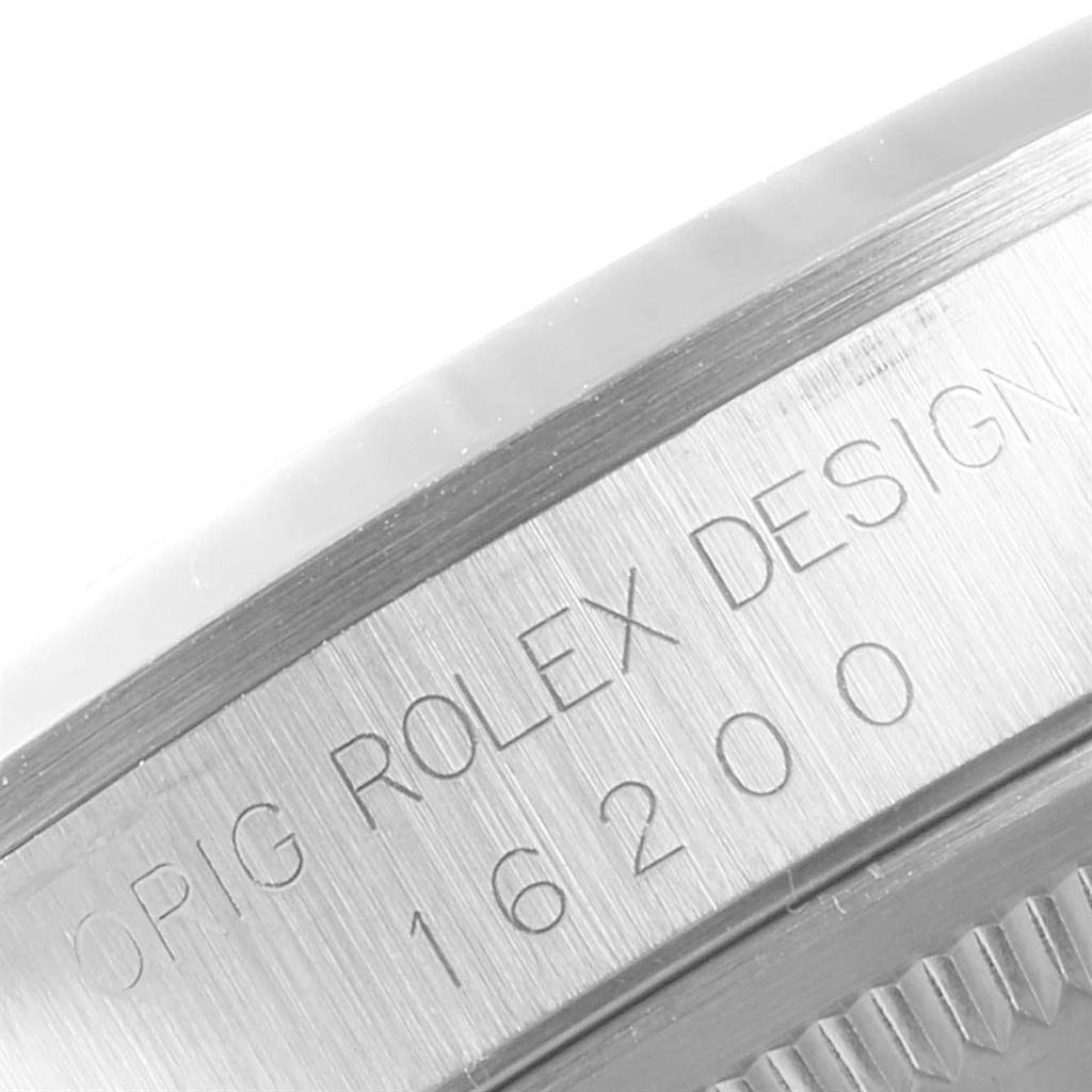 This image shows a close-up of the engraved serial number and design text on the side of a Rolex Datejust 16200 Men's Stainless Steel White Dial 16200 Men's Stainless Steel White Dial watch case.