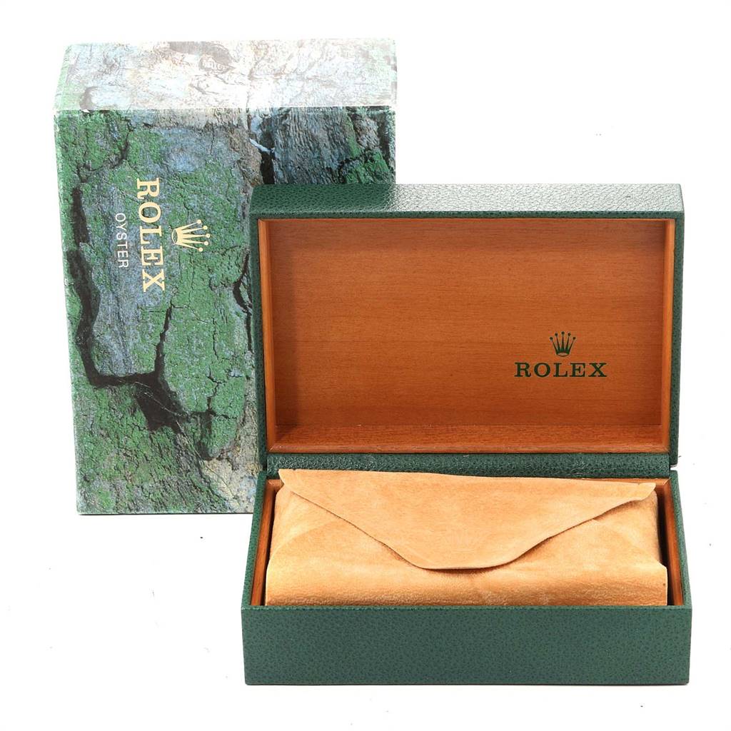 The image shows an open Rolex Datejust 16233 Men
s Steel and Gold (two tone) Silver Dial 16233 Men
s Steel and Gold (two tone) Silver Dial watch box with a green exterior, brown interior, and a Rolex logo, along with its outer packaging.