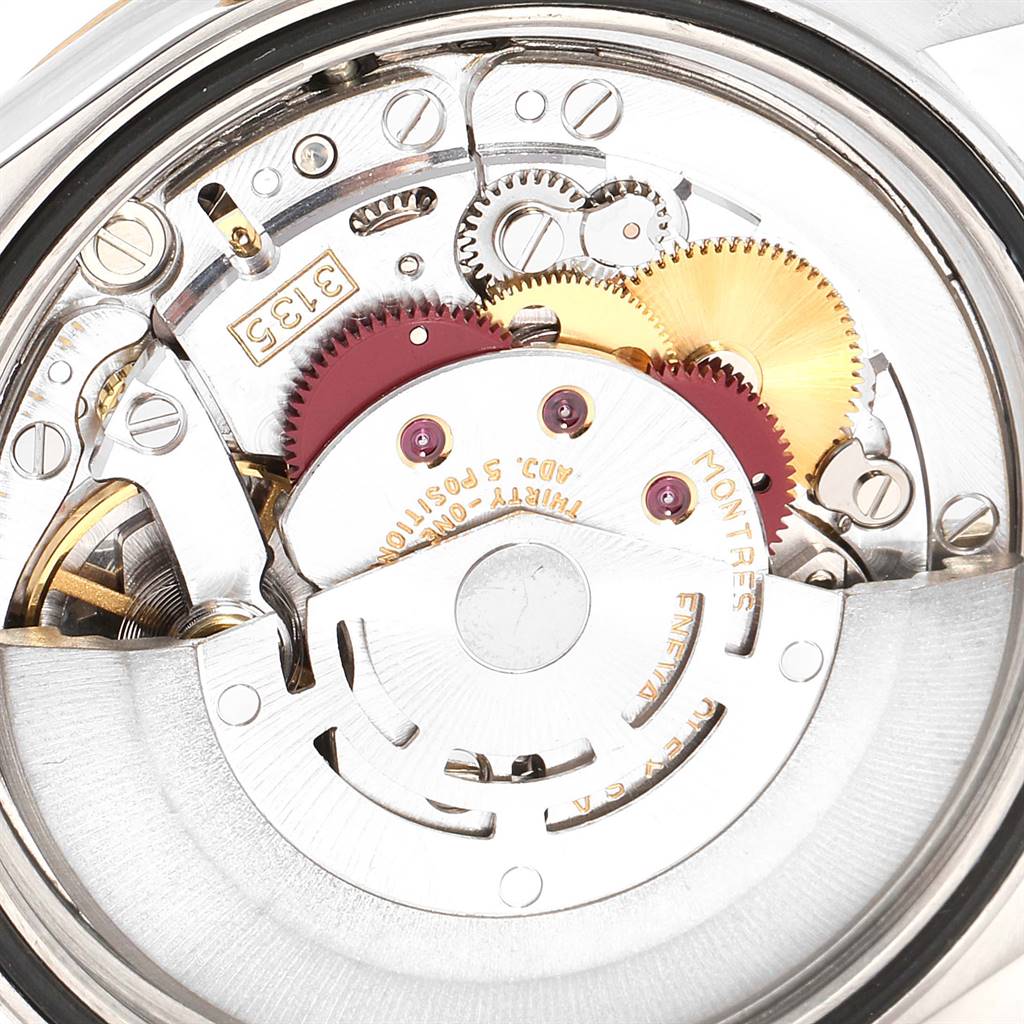 The image shows an inside view of a Rolex Datejust 16233 Men's Steel and Gold (two tone) Champagne Dial 16233 Men's Steel and Gold (two tone) Champagne Dial watch's movement and intricate gears.