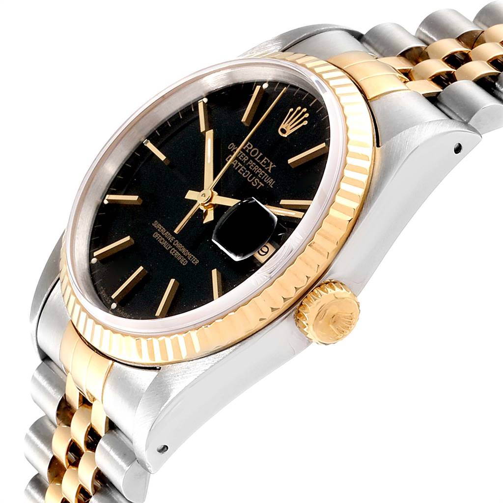 The Rolex Datejust 16233 Men
s Steel and Gold (two tone) Black Dial 16233 Men
s Steel and Gold (two tone) Black Dial watch is shown at an angled close-up, displaying its black dial, date feature, fluted bezel, and two-tone band.