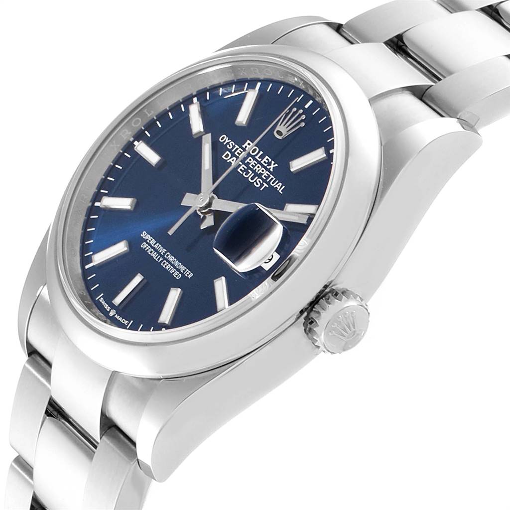 The image shows a side view of a Rolex Datejust 126200 Men's Stainless Steel Blue Dial 126200 Men's Stainless Steel Blue Dial watch, highlighting the crown, bracelet, bezel, and dial with date magnifier.