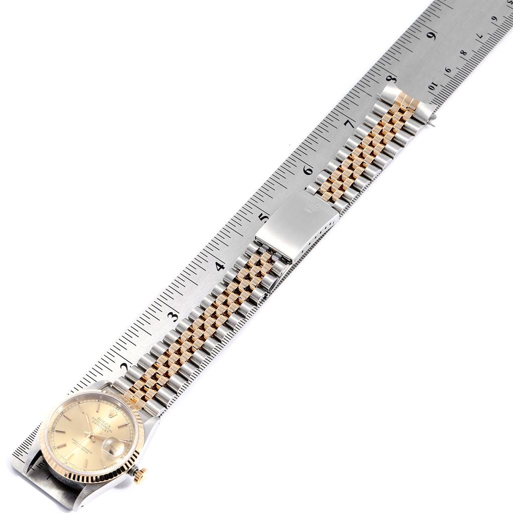 The image shows a Rolex Datejust 16233 Men
s Steel and Gold (two tone) Champagne Dial 16233 Men
s Steel and Gold (two tone) Champagne Dial watch laid flat alongside a ruler, displaying the band and watch face.