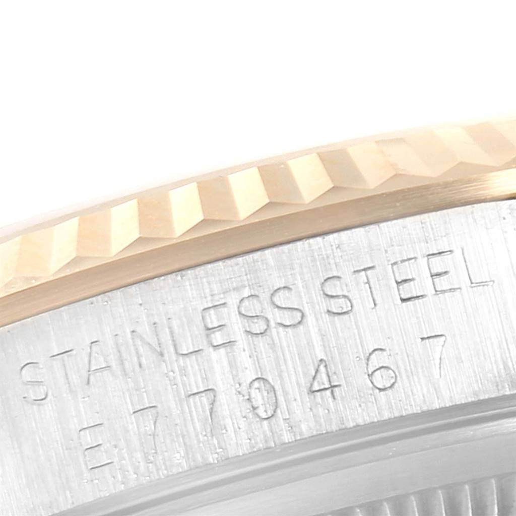 The image shows a close-up of the Rolex Datejust 16233 Men
s Steel and Gold (two tone) Champagne Dial 16233 Men
s Steel and Gold (two tone) Champagne Dial model
s stainless steel case and fluted bezel, highlighting the engraved serial number.