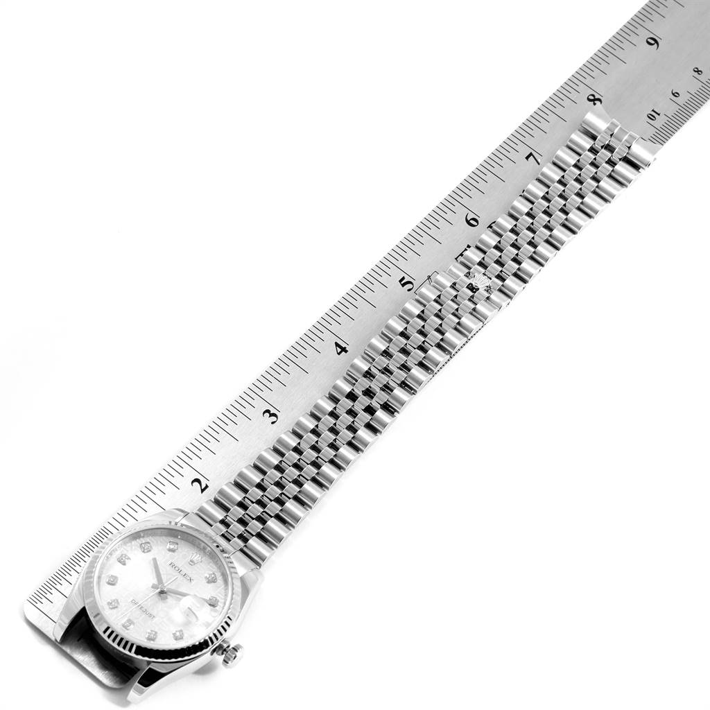 The Rolex Datejust 116234 Men's Stainless Steel Silver Dial 116234 Men's Stainless Steel Silver Dial watch is laid out flat beside a ruler, displaying its watch face and entire bracelet.