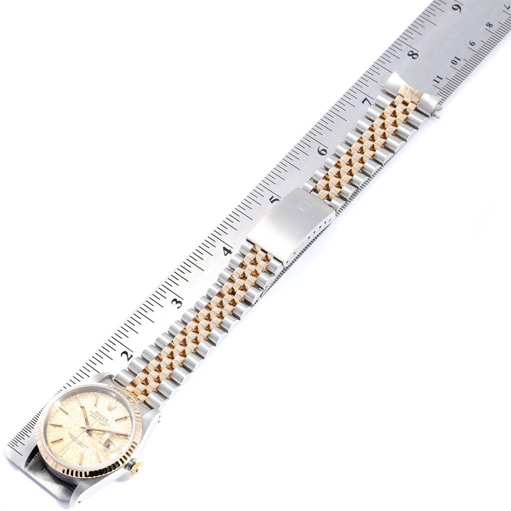 The Rolex Datejust 16233 Men's Steel and Gold (two tone) Champagne Dial 16233 Men's Steel and Gold (two tone) Champagne Dial watch is photographed from above, showing the face, bezel, and two-tone bracelet beside a ruler.