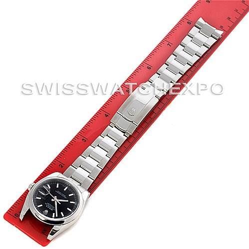 The image shows a Rolex Datejust 116200 Men's Stainless Steel Black Dial 116200 Men's Stainless Steel Black Dial watch placed alongside a red ruler, highlighting the watch face, bracelet, and clasp.