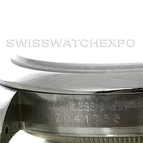 The image shows a close-up of the side of a Rolex Datejust 116200-BKRJ Men
s Stainless Steel Black Dial 116200-BKRJ Men
s Stainless Steel Black Dial watch, specifically highlighting the stainless steel case and serial number.