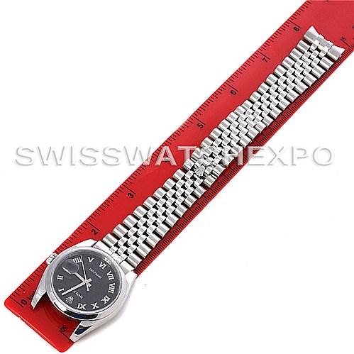 This image shows a top view of a Rolex Datejust 116200-BKRJ Men
s Stainless Steel Black Dial 116200-BKRJ Men
s Stainless Steel Black Dial watch placed on a red ruler, displaying the face and full metal bracelet.