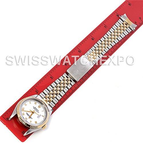 This image shows a top-down view of a Rolex Datejust 16233 Men's Steel and Gold (two tone) White Dial 16233 Men's Steel and Gold (two tone) White Dial watch, highlighting the face and full bracelet against a red ruler for scale.