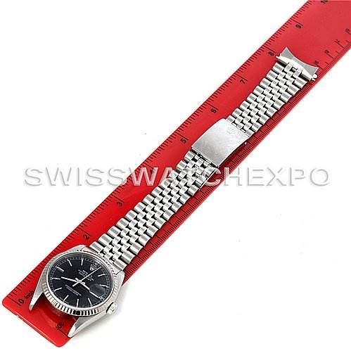 The image shows a Rolex Datejust 16234 Men's Stainless Steel Black Dial 16234 Men's Stainless Steel Black Dial watch laid flat, displaying the face, bracelet, and clasp alongside a red ruler for scale.