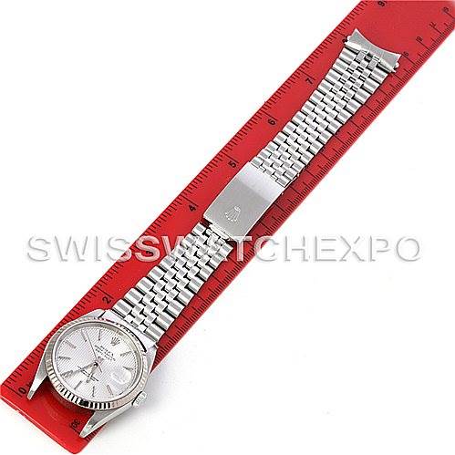 The image shows a Rolex Datejust 16234 Men's Stainless Steel Silver Dial 16234 Men's Stainless Steel Silver Dial model watch laid flat alongside a red ruler, displaying the watch face and the full metal bracelet band.