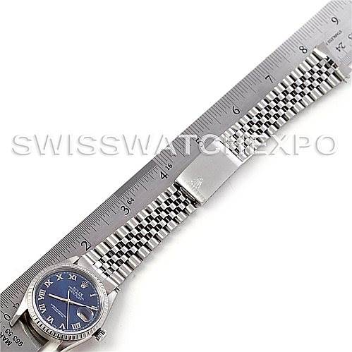 The image displays a Rolex Datejust 16220 Men's Stainless Steel Blue Dial 16220 Men's Stainless Steel Blue Dial watch laid flat next to a ruler, showing the blue face, bezel, and jubilee bracelet.