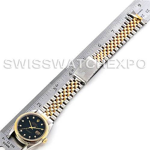 This image shows a Rolex Datejust 16233 Men's Steel and Gold (two tone) Black Dial 16233 Men's Steel and Gold (two tone) Black Dial watch at a top-down angle, displaying its face and Jubilee bracelet measured with a ruler.