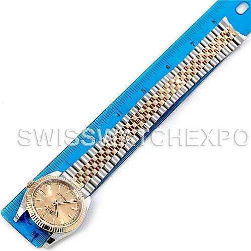 The image shows a Rolex Datejust 116233CSJ Men
s Stainless Steel Champagne Dial 116233CSJ Men
s Stainless Steel Champagne Dial watch laid flat next to a blue ruler, displaying its face and full bracelet.
