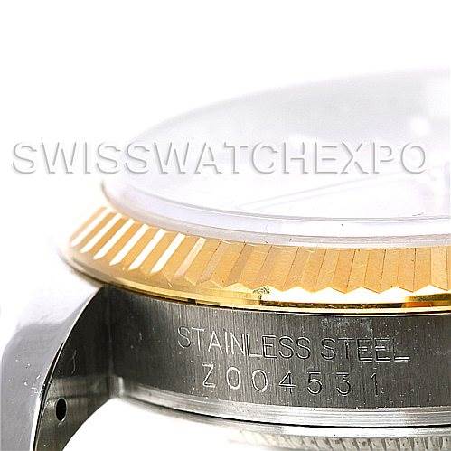 The image shows a close-up side view of a Rolex Datejust 116233CSJ Men
s Stainless Steel Champagne Dial 116233CSJ Men
s Stainless Steel Champagne Dial watch bezel and case with "STAINLESS STEEL" engraved.