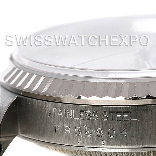 This close-up image of a Rolex Datejust 16234 Men's Stainless Steel Silver Dial 16234 Men's Stainless Steel Silver Dial watch shows the stainless steel case with engravings and a portion of the bezel.