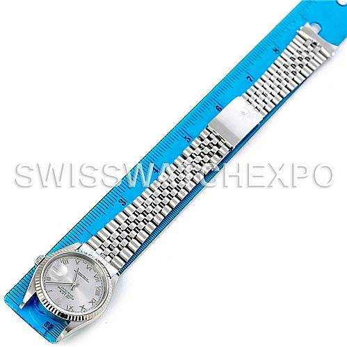The image shows a Rolex Datejust 16234 Men's Stainless Steel Silver Dial 16234 Men's Stainless Steel Silver Dial watch laid flat, fully extended, with a blue ruler underneath it for size reference.