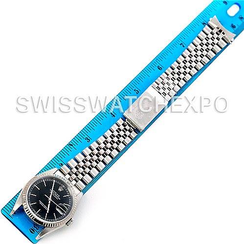 The image shows a Rolex Datejust 16234 Men's Stainless Steel Black Dial 16234 Men's Stainless Steel Black Dial watch horizontally placed alongside a ruler, displaying its face, band, and clasp.