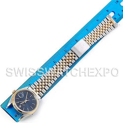 The image shows a Rolex Datejust 16233 Men's Steel and Gold (two tone) Blue Dial 16233 Men's Steel and Gold (two tone) Blue Dial watch laid flat with the dial and jubilee bracelet fully visible, placed on a blue ruler.
