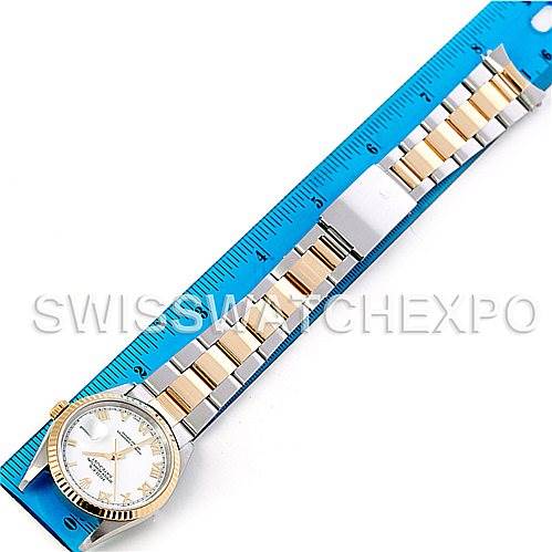 The Rolex Datejust 16233 Men's Steel and Gold (two tone) White Dial 16233 Men's Steel and Gold (two tone) White Dial watch is shown from an overhead angle, highlighting the bracelet and face alongside a ruler.