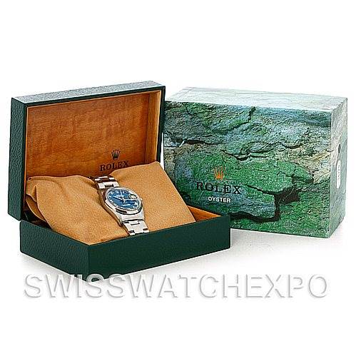 The image shows a Rolex Datejust 16200 Men's Stainless Steel Blue Dial 16200 Men's Stainless Steel Blue Dial watch displayed in an open green and brown box with an additional closed box beside it.