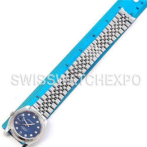 This image shows a top-down view of a Rolex Datejust 116234 Men's Stainless Steel Blue Dial 116234 Men's Stainless Steel Blue Dial watch with a Jubilee bracelet alongside a blue ruler for scale.