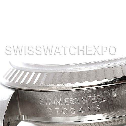 The image shows a close-up view of the side of a Rolex Datejust 116234 Men's Stainless Steel White Dial 116234 Men's Stainless Steel White Dial, highlighting part of the bezel and stainless steel casing with engraved serial number.