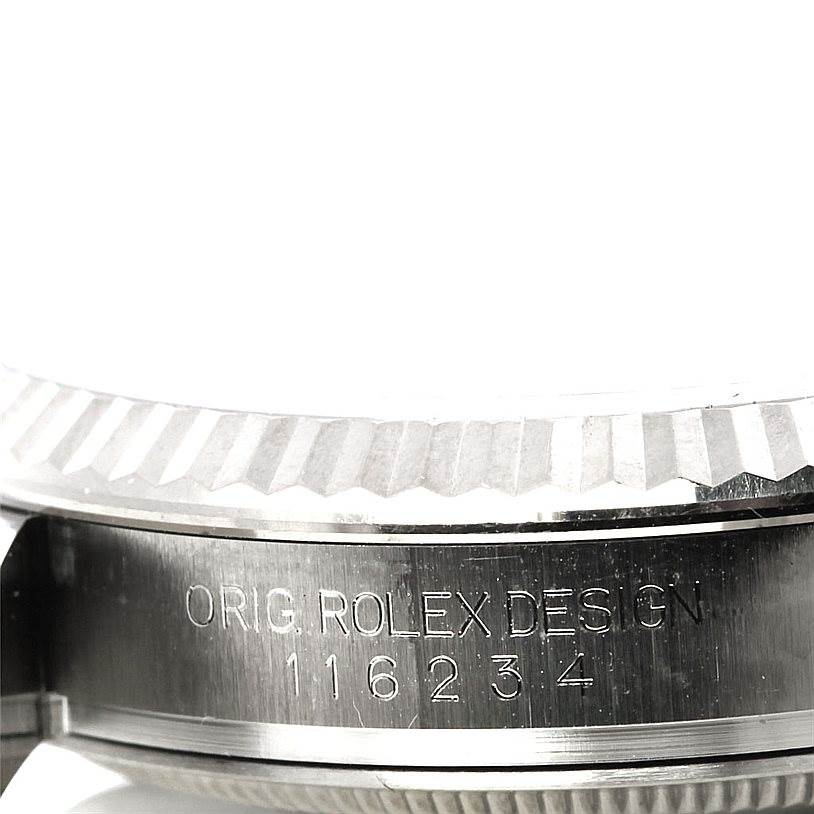 This image shows a close-up of the engraved case side of a Rolex Datejust 116234 Men
s Stainless Steel Silver Dial 116234 Men
s Stainless Steel Silver Dial watch, focusing on the serial number.