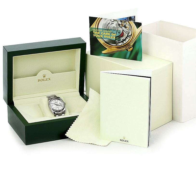 The image shows a Rolex Datejust 116234 Men
s Stainless Steel Silver Dial 116234 Men
s Stainless Steel Silver Dial watch in its opened green and cream box with accompanying booklets and a cleaning cloth.