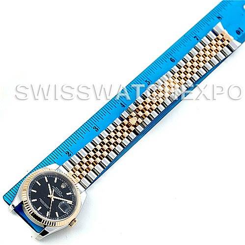 The image shows a Rolex Datejust 116233 Men
s Stainless Steel Black Dial 116233 Men
s Stainless Steel Black Dial watch laid flat against a blue ruler, displaying the face, bezel, and entire bracelet.