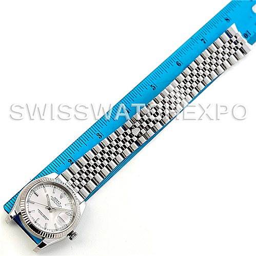 The image shows a top-down view of a Rolex Datejust 116234 Men's Stainless Steel Silver Dial 116234 Men's Stainless Steel Silver Dial watch with a silver dial and Jubilee bracelet next to a blue measuring ruler.