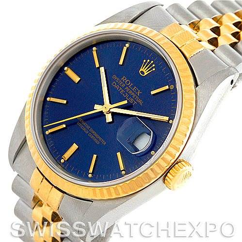 This image shows the Rolex Datejust 16233 Men
s Steel and Gold (two tone) Blue Dial 16233 Men
s Steel and Gold (two tone) Blue Dial watch from an angle focusing on its face, bezel, crown, and part of its band.