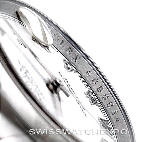 The image shows a close-up of the dial and rehaut of a Rolex Datejust 116200 Men
s Stainless Steel White Dial 116200 Men
s Stainless Steel White Dial watch, including part of the crown and serial number engraving.
