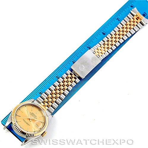 The image shows a top-down view of a Rolex Datejust 16233 Men's Steel and Gold (two tone) Champagne Dial 16233 Men's Steel and Gold (two tone) Champagne Dial watch, highlighting its face and two-tone Jubilee bracelet against a ruler for scale.