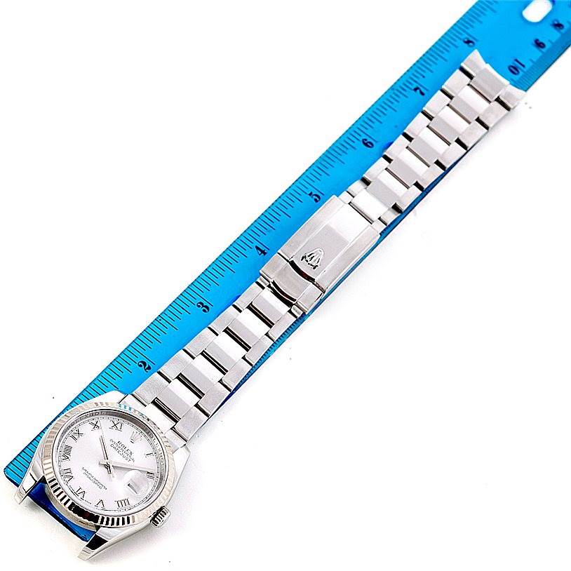 The image shows a top view of a Rolex Datejust 116234 Men's Stainless Steel Silver Dial 116234 Men's Stainless Steel Silver Dial watch alongside a blue ruler.