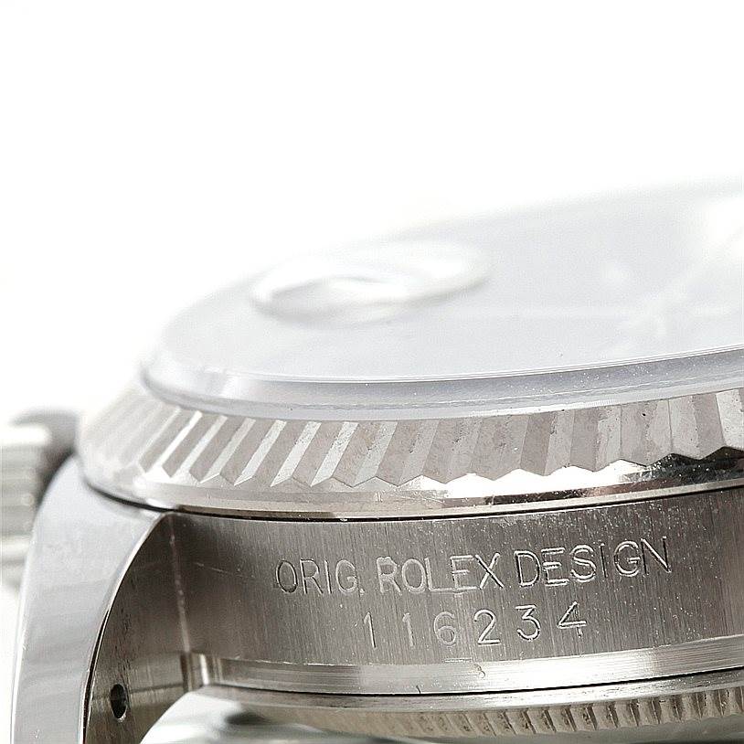This close-up image shows the side of a Rolex Datejust 116234 Men
s Stainless Steel Black Dial 116234 Men
s Stainless Steel Black Dial watch, highlighting the bezel and part of the case with the serial number.
