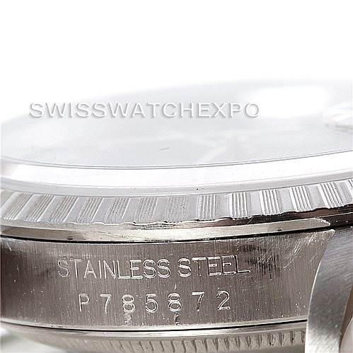 The image shows a close-up of the case side of a Rolex Datejust 16220 Men's Stainless Steel Blue Dial 16220 Men's Stainless Steel Blue Dial, focusing on the fluted bezel and engraved serial number.