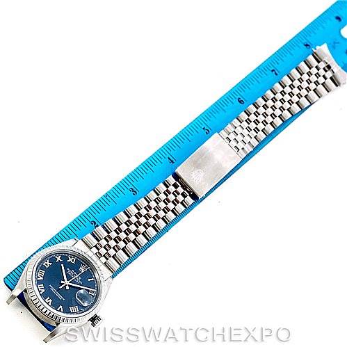 The image shows a Rolex Datejust 16220 Men's Stainless Steel Blue Dial 16220 Men's Stainless Steel Blue Dial watch with a full view of the face, bracelet, and part of its clasp, positioned alongside a blue ruler.